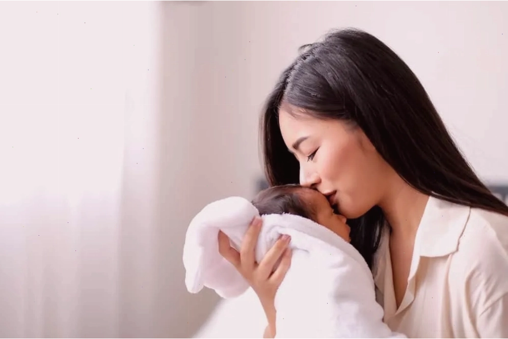 Bé sơ sinh đang được mẹ vỗ lưng nhẹ nhàng sau khi bú để trị nấc cụt