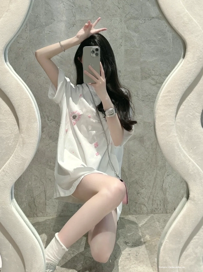 Cô gái xinh che mặt bằng điện thoại trước gương