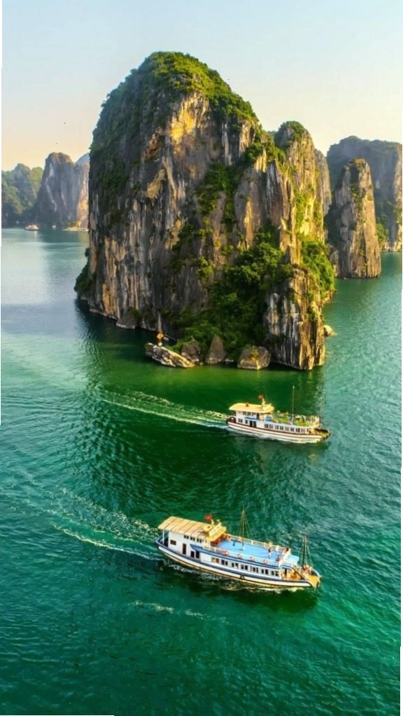 Du thuyền nhỏ giữa vịnh biển xanh và núi đá, hình nền điện thoại gợi cảm giác thư thái